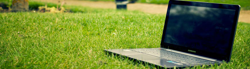Geöffneter Laptop auf Rasenfläche